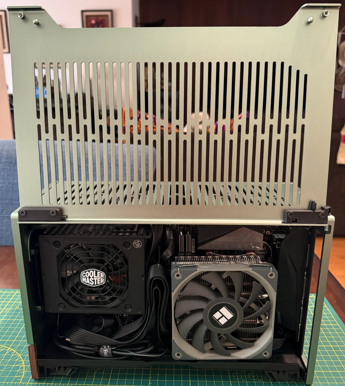 The opposite side of the open Terra, with the Cooler Master power supply beside the low-profile CPU cooler and bundled cables below.